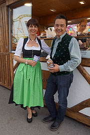 Daniela und Gregor Merkl vor Merkl's Mandelhütte heißen ihre Wiesnkunden willkommen (©Foto: Martin Schmitz)